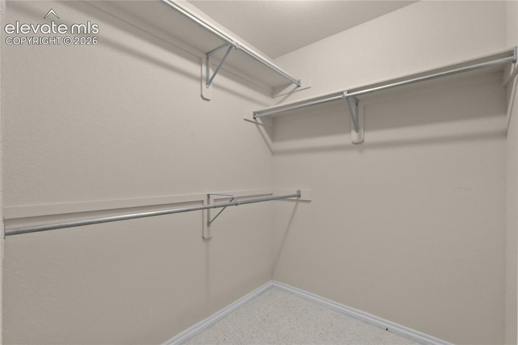 Image 34 of 41: Walk-in closet featuring light-colored walls, white trim, and light speckle