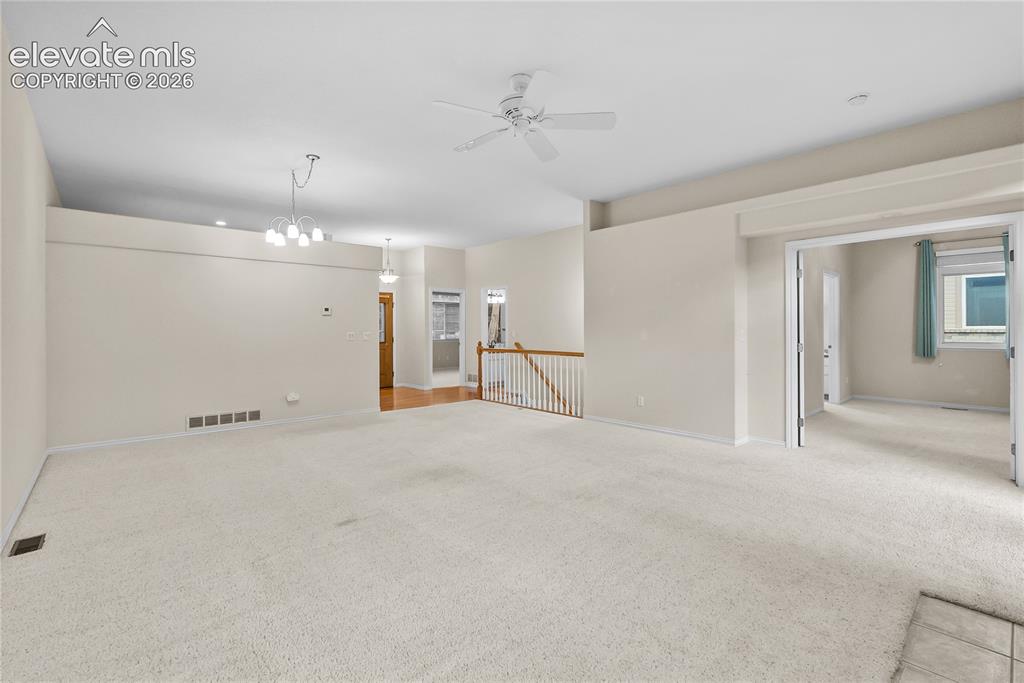 Image 9 of 41: Expansive carpeted living area with a ceiling fan