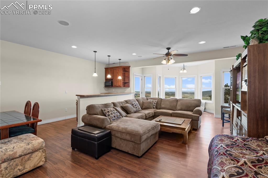 Image 35 of 50: Living room with dark hardwood / wood-style flooring and ceiling fan