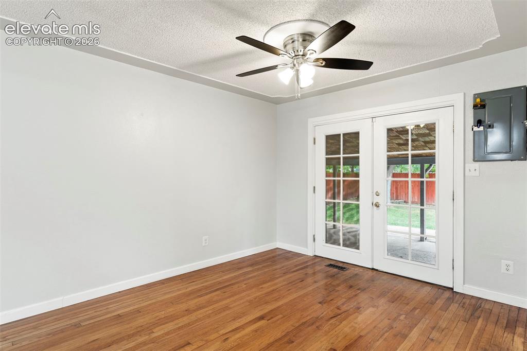 Image 19 of 36: Wood-finish flooring with white trim, light gray walls, and a ceiling fan w