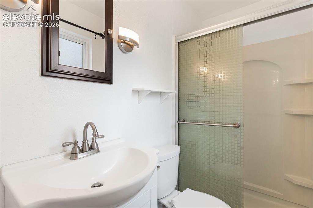 Image 24 of 36: Wall-mounted vanity with a single basin sink and brushed nickel faucet