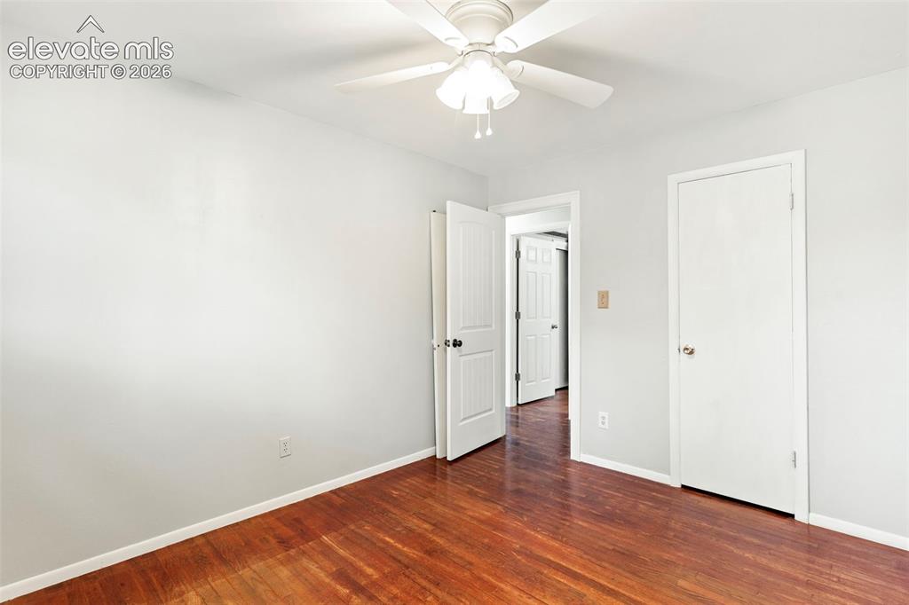 Image 26 of 36: Hardwood flooring, light gray wall paint, white trim, white doors, and a ce