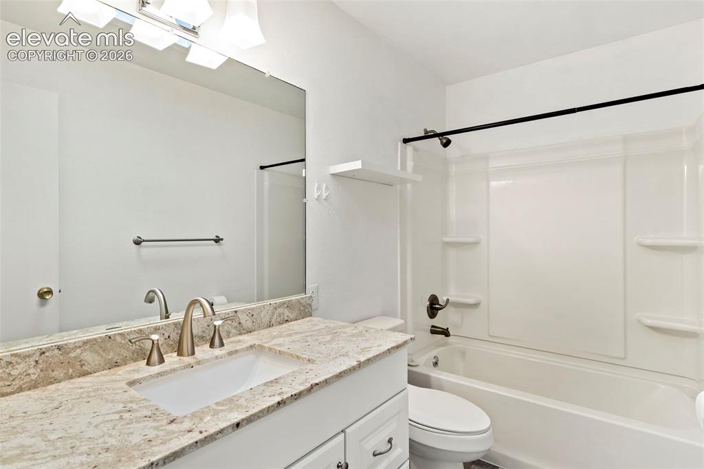 Image 27 of 36: Vanity with integrated sink, stone countertop, brushed nickel faucet, full-