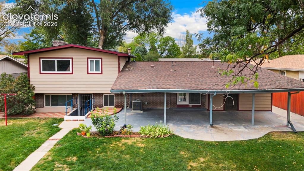 Image 5 of 36: Expansive backyard with a covered patio, mature trees, and a manicured lawn