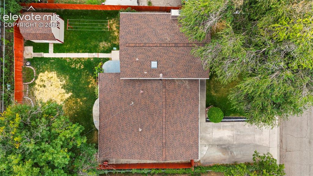 Image 7 of 36: Brown shingle roof with skylight, detached storage shed, privacy fencing, a