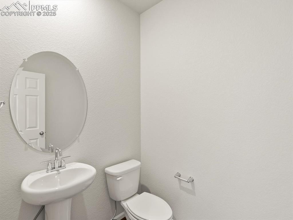 Image 10 of 26: Half bath featuring a textured wall and toilet