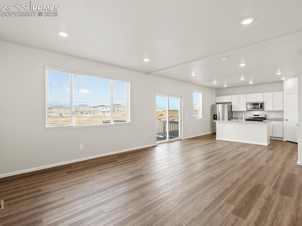 Image 11 of 26: Unfurnished living room featuring light wood finished floors and recessed l