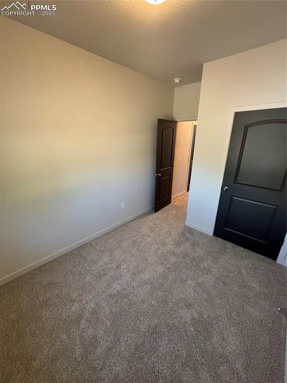 Image 9 of 13: Unfurnished bedroom with carpet flooring and a textured ceiling