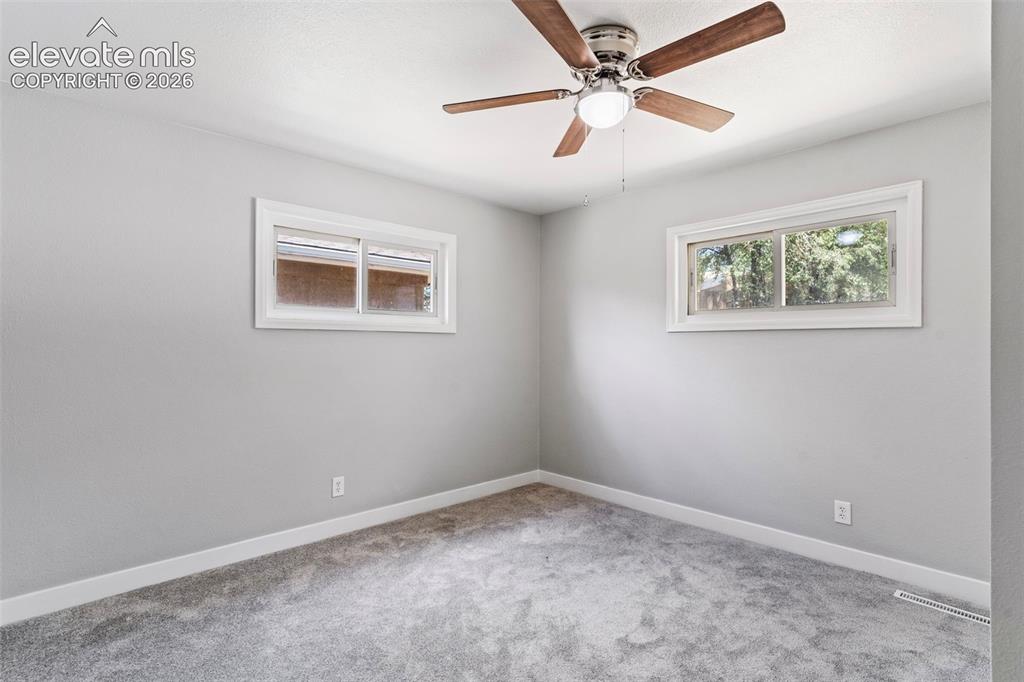 Image 23 of 33: Neutral wall tones, gray carpeting, dual windows, and a wood-finish ceiling