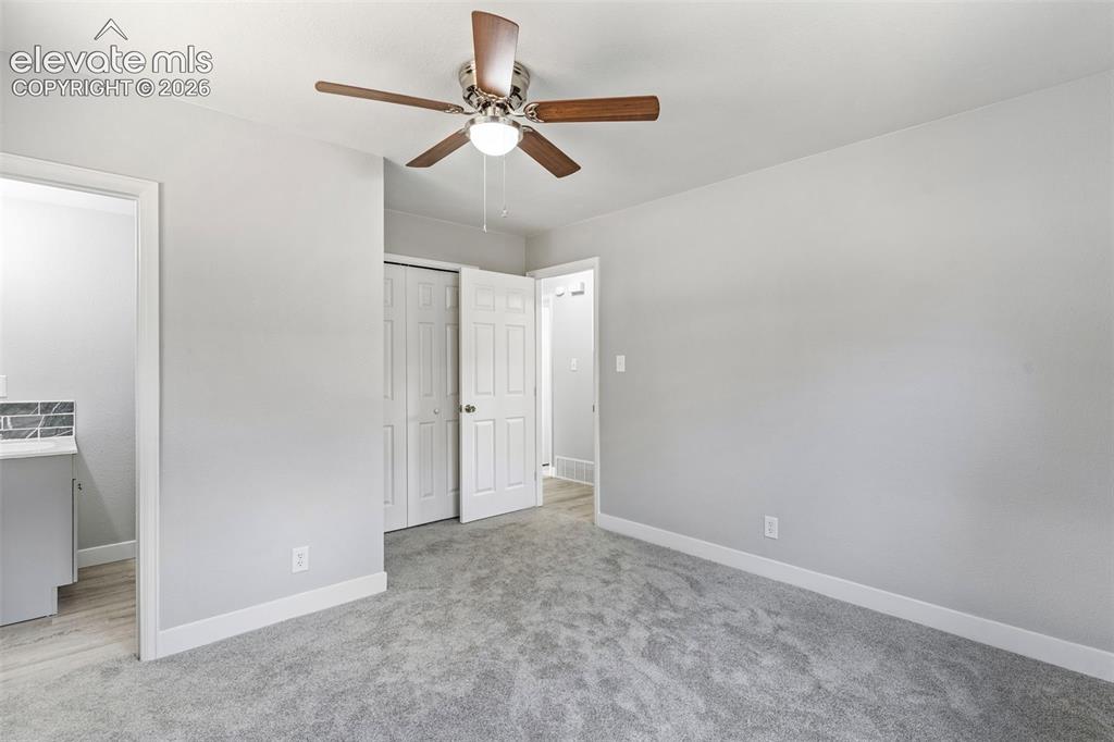Image 24 of 33: Neutral wall paint with white trim, ceiling fan with light fixture, gray ca