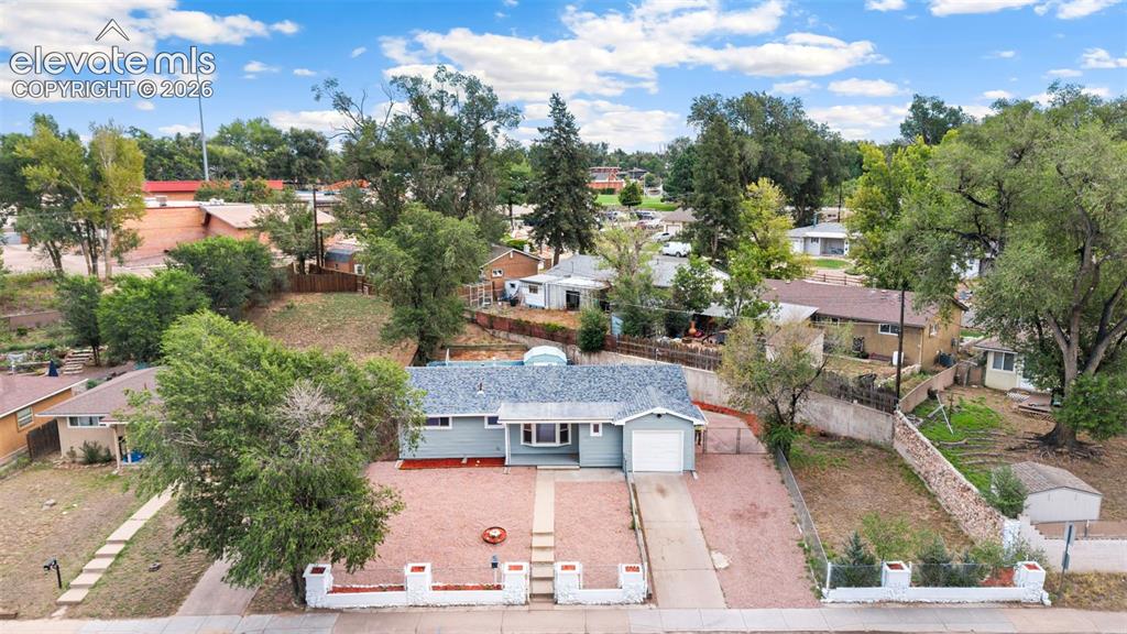Image 3 of 33: Light blue exterior with white trim, attached single-car garage, red gravel