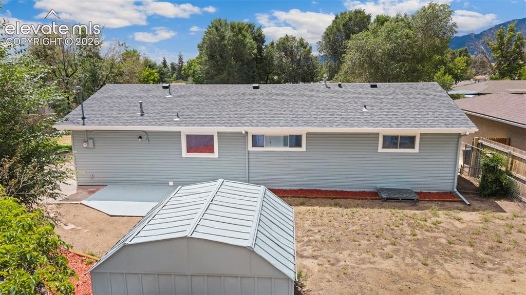 Image 8 of 33: Light blue siding exterior with a dark gray asphalt shingle roof