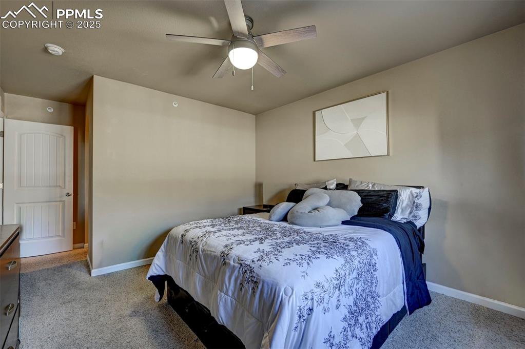 Image 15 of 29: Bedroom with light carpet and a ceiling fan