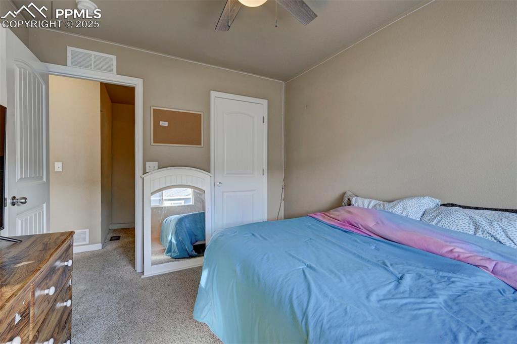 Image 19 of 29: Carpeted bedroom with ceiling fan and a closet
