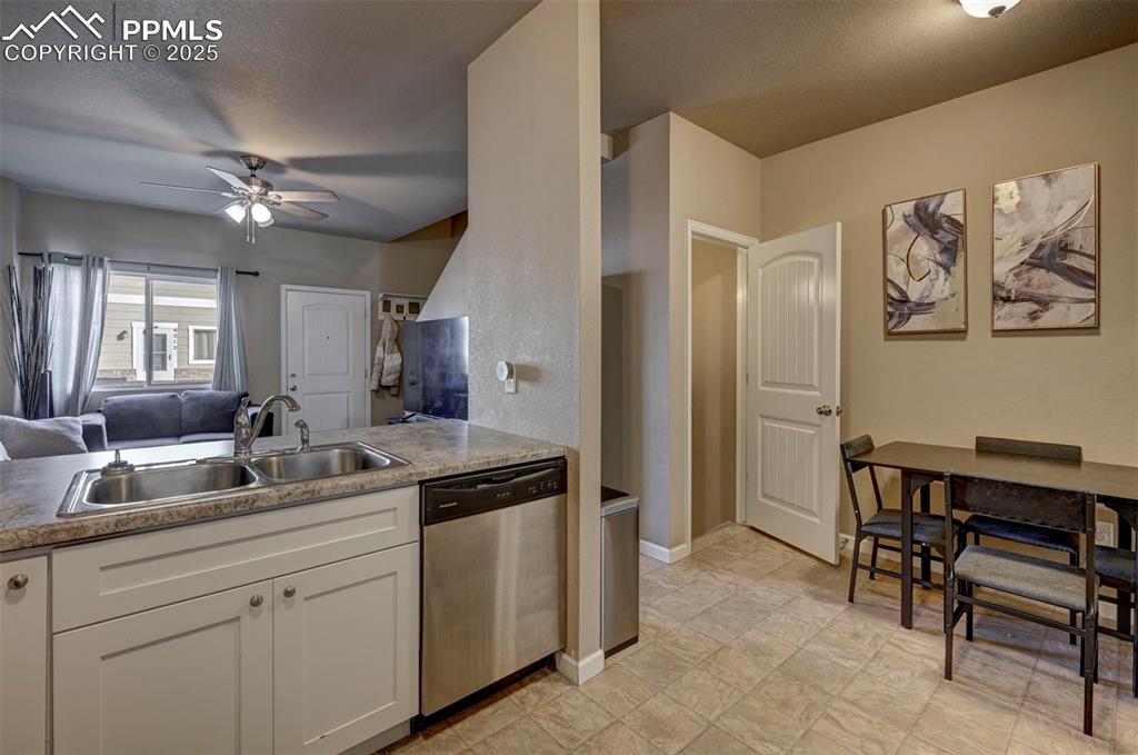 Image 6 of 29: Kitchen featuring open floor plan, stainless steel dishwasher, ceiling fan,