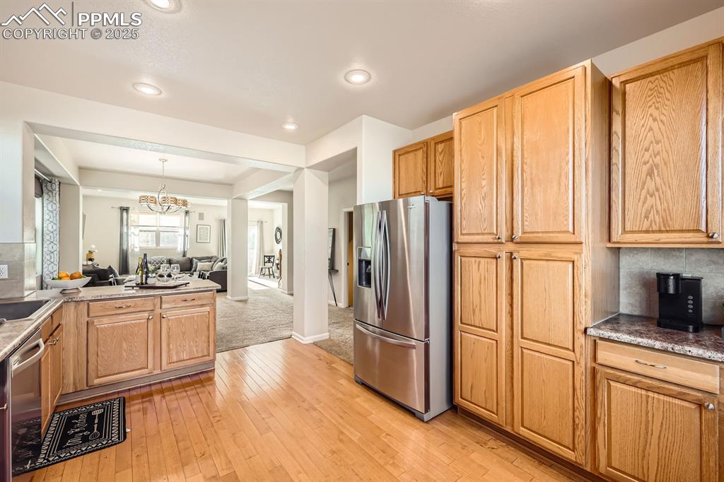 Image 12 of 39: Kitchen featuring backsplash, appliances with stainless steel finishes, ope