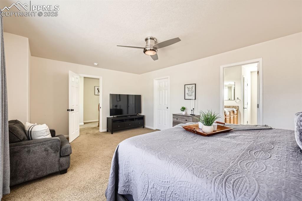 Image 16 of 39: Bedroom featuring light colored carpet, ceiling fan, and ensuite bathroom