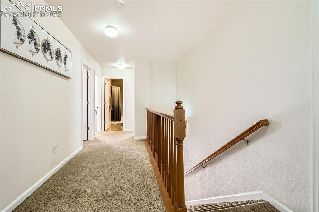 Image 27 of 39: Corridor featuring an upstairs landing and carpet floors