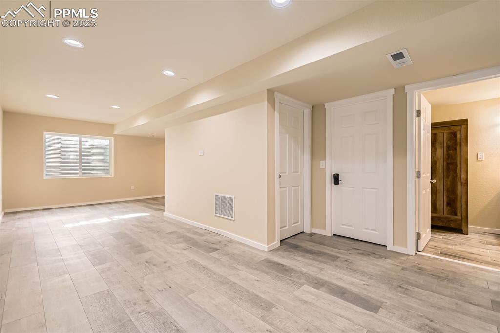 Image 29 of 39: Below grade area featuring light wood-style flooring and recessed lighting