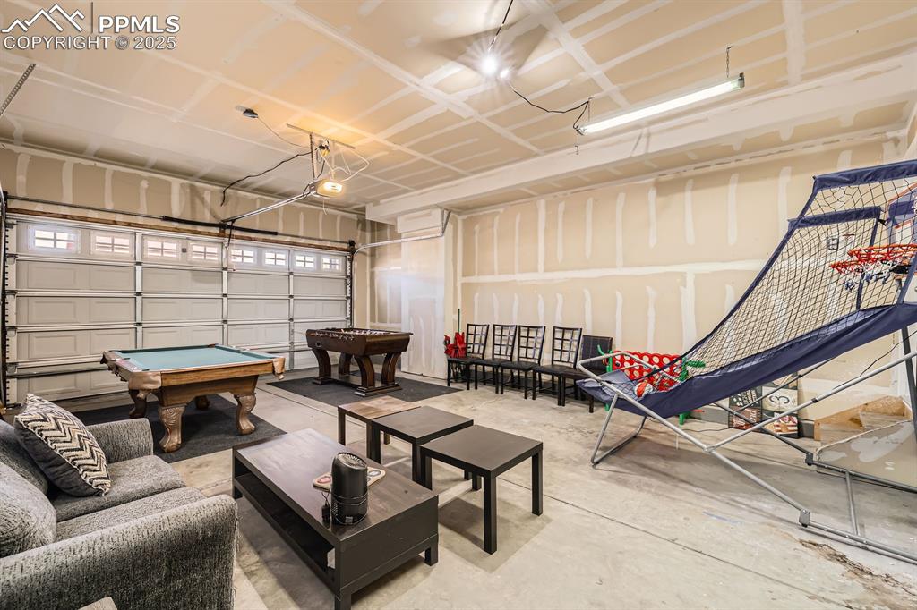 Image 36 of 39: Rec room with billiards table, a garage, and concrete flooring
