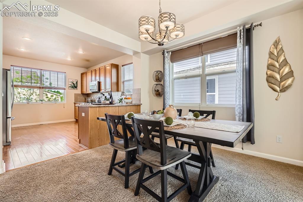 Image 8 of 39: Dining area featuring light carpet, healthy amount of natural light, a chan