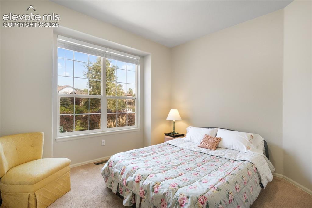 Image 26 of 50: Carpeted room featuring a large window with white trim, offering natural li