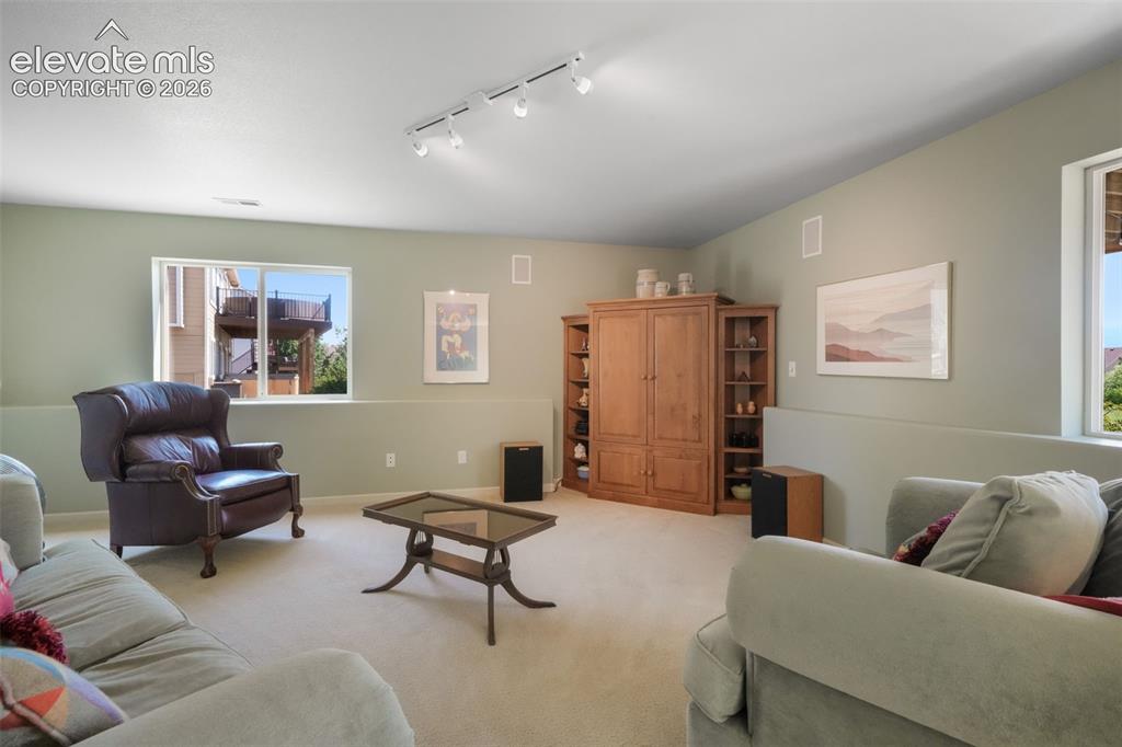 Image 29 of 50: Bedroom featuring a large multi-pane window with blinds, neutral-toned wall
