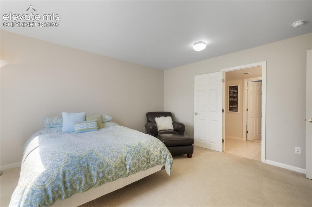 Image 39 of 50: Recessed lighting illuminates the neutral-toned walls and carpeted flooring