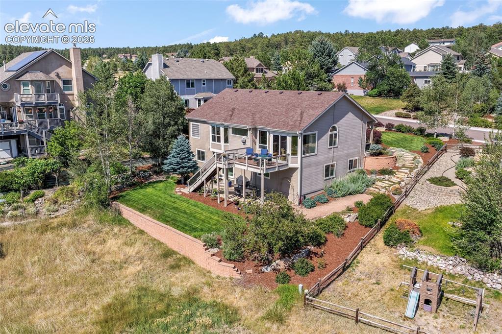 Image 47 of 50: Expansive lawn area featuring a multi-level deck system with stairs, an und