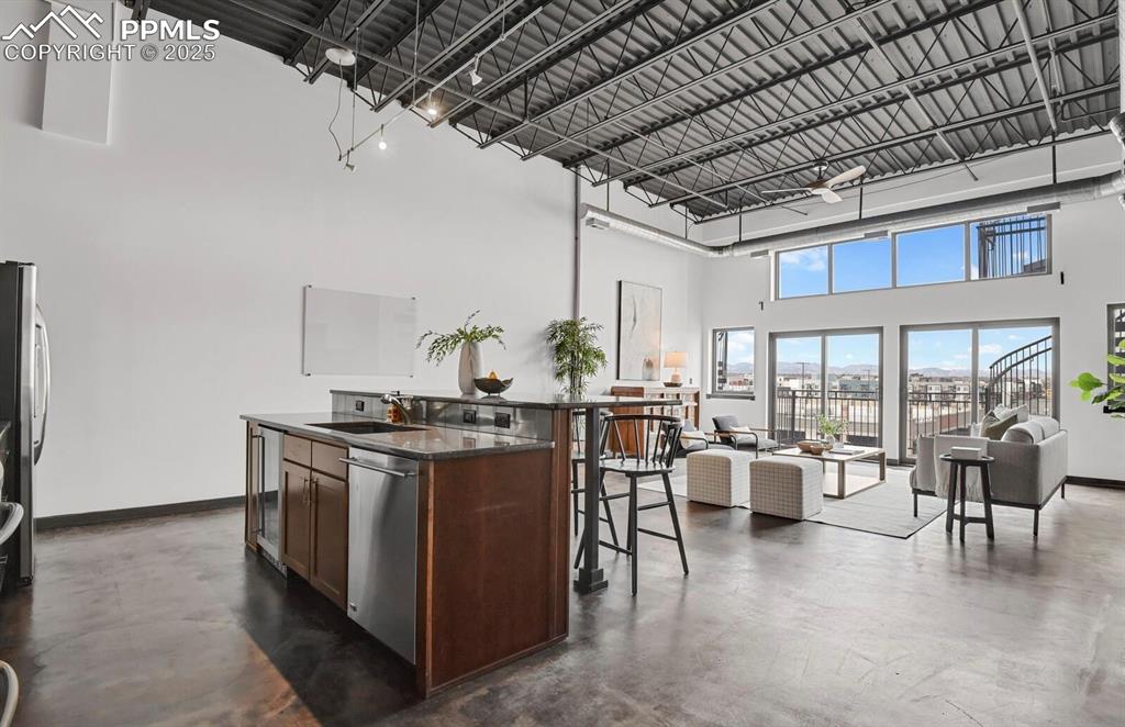 Image 11 of 45: Kitchen featuring baseboards, a high ceiling, a sink, stainless steel dishw