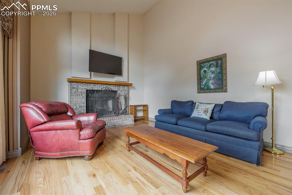 Image 14 of 40: Family room off of kitchen and nook with brick surround wood burning firepl