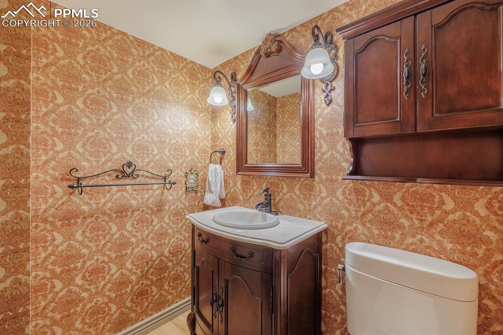 Image 16 of 40: Powder room off of garage and hall to dining area