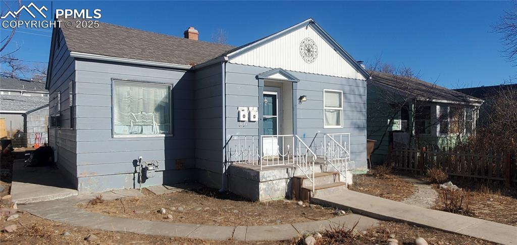 Image 3 of 22: View of front of house with a shingled roof and a chimney