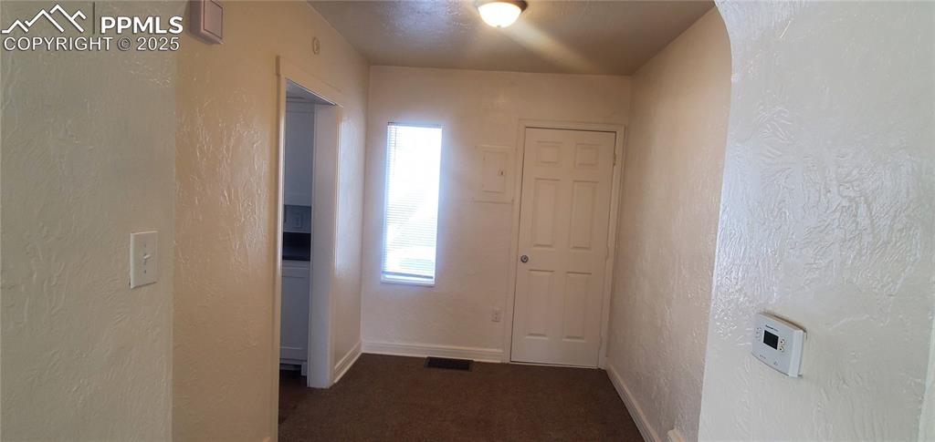 Image 6 of 22: Corridor featuring carpet flooring, baseboards, and a textured wall