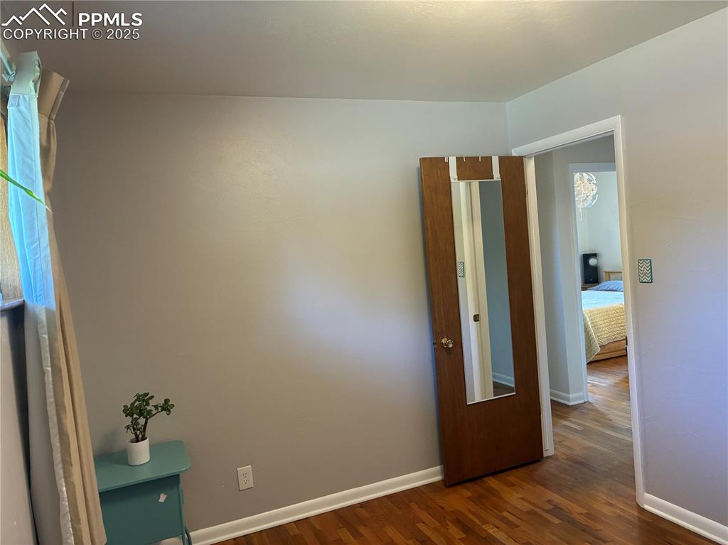 Image 14 of 39: Empty room with wood flooring and baseboards