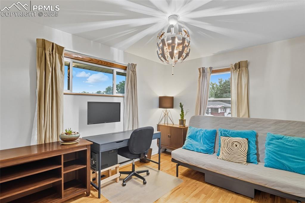 Image 16 of 39: Bedroom featuring wood finished floors, plenty of natural light, and a chan