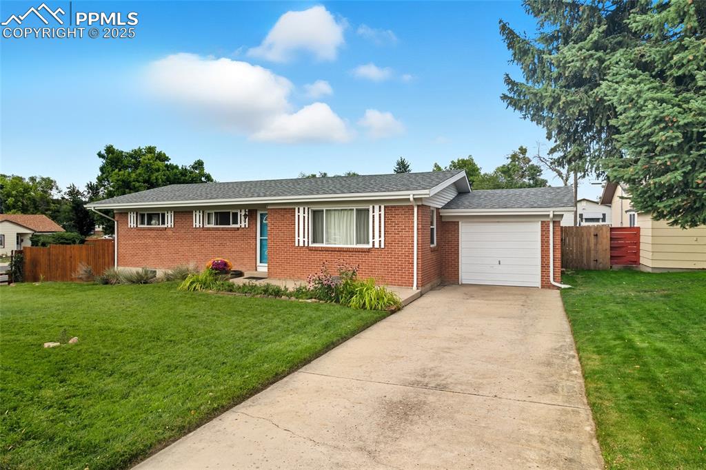 Image 2 of 39: Ranch-style house featuring brick siding, concrete driveway, roof with shin