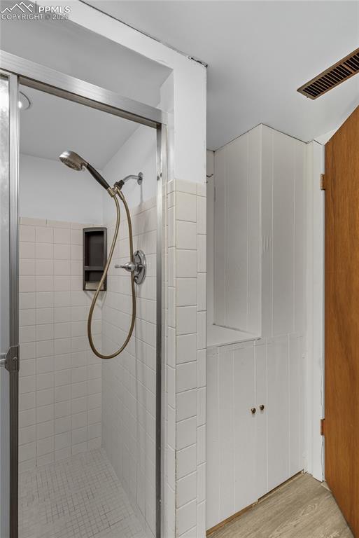 Image 30 of 39: Full bathroom featuring a shower stall and light wood-type flooring