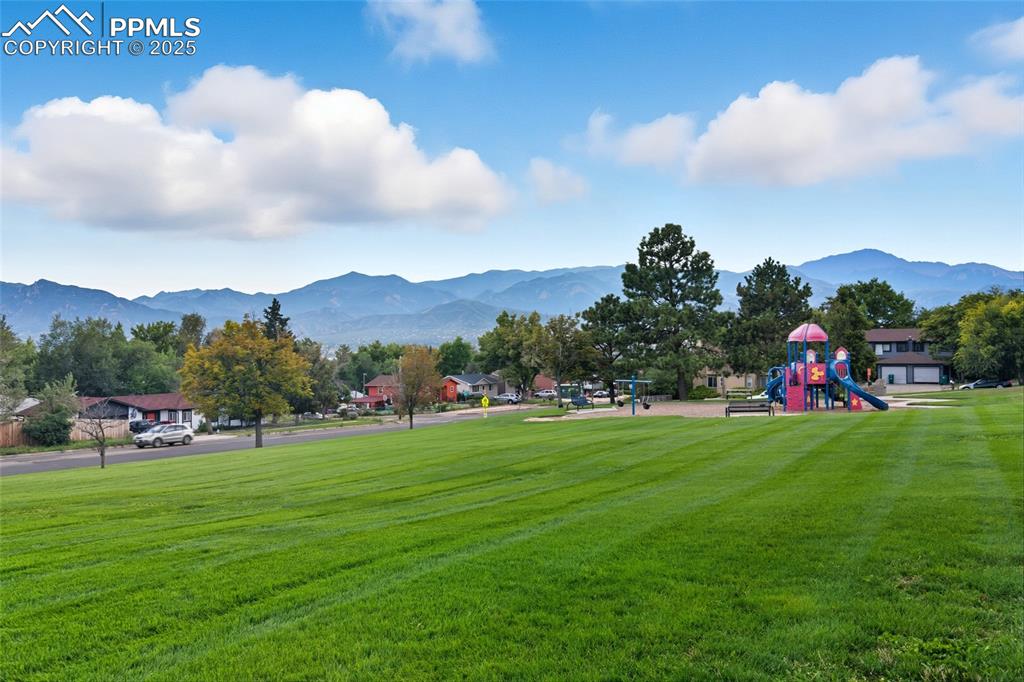 Image 37 of 39: Surrounding community with a mountain view and a yard