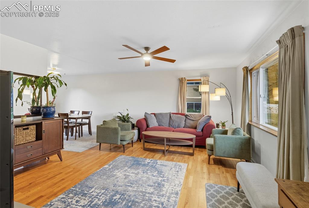 Image 5 of 39: Living room with light wood finished floors and ceiling fan
