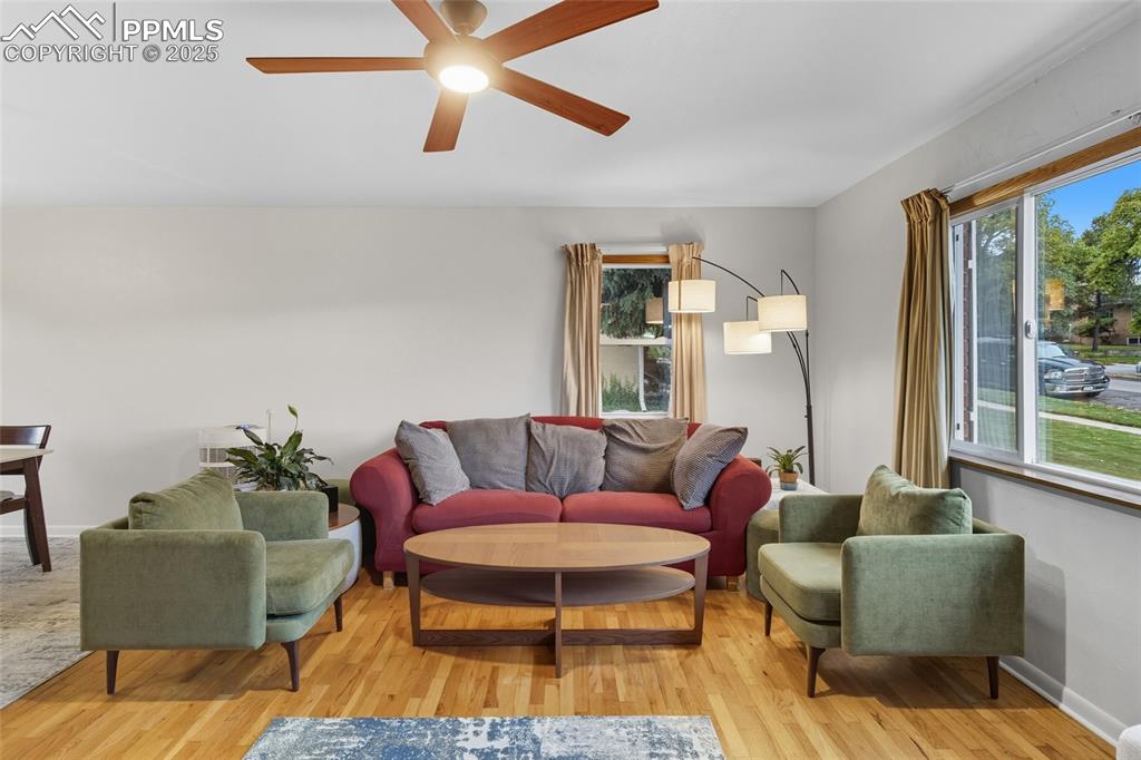 Image 6 of 39: Living room with light wood finished floors and ceiling fan