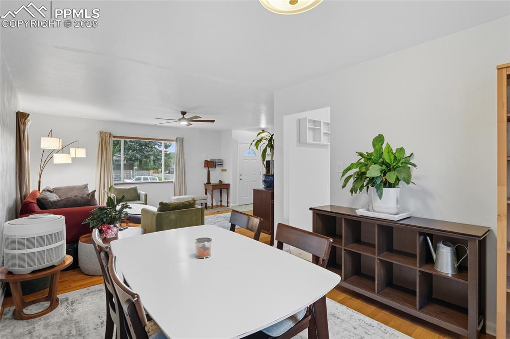 Image 9 of 39: Dining area with light wood-style floors and ceiling fan