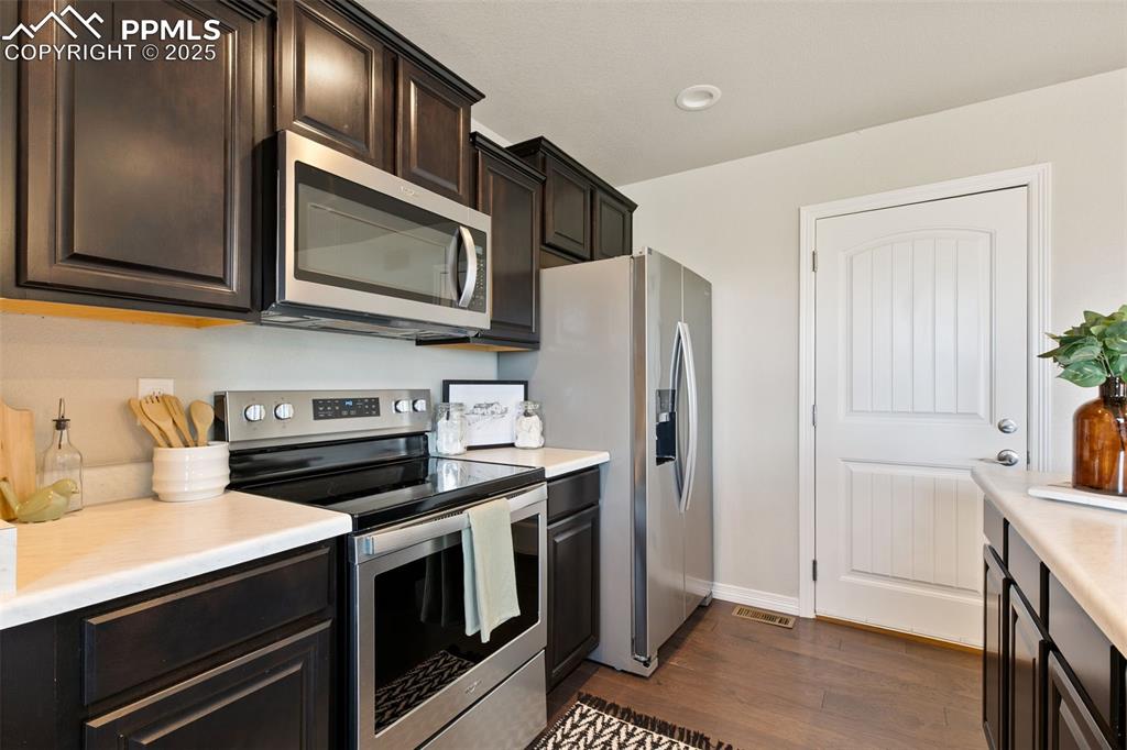 Image 12 of 28: Kitchen featuring appliances with stainless steel finishes, light counterto