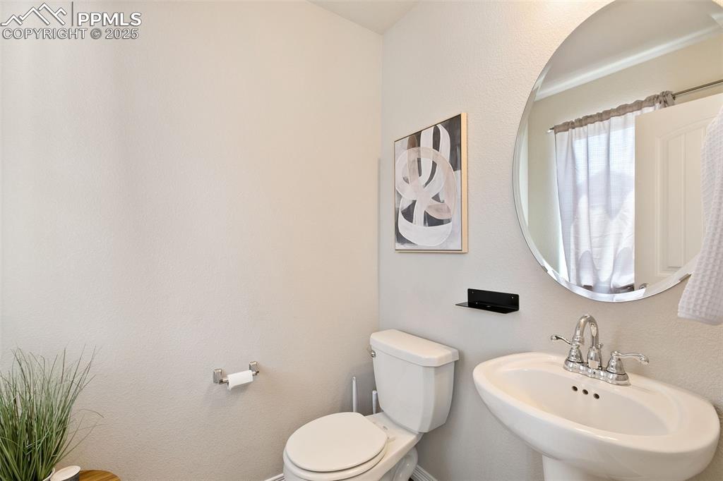 Image 14 of 28: Half bathroom featuring toilet and a sink