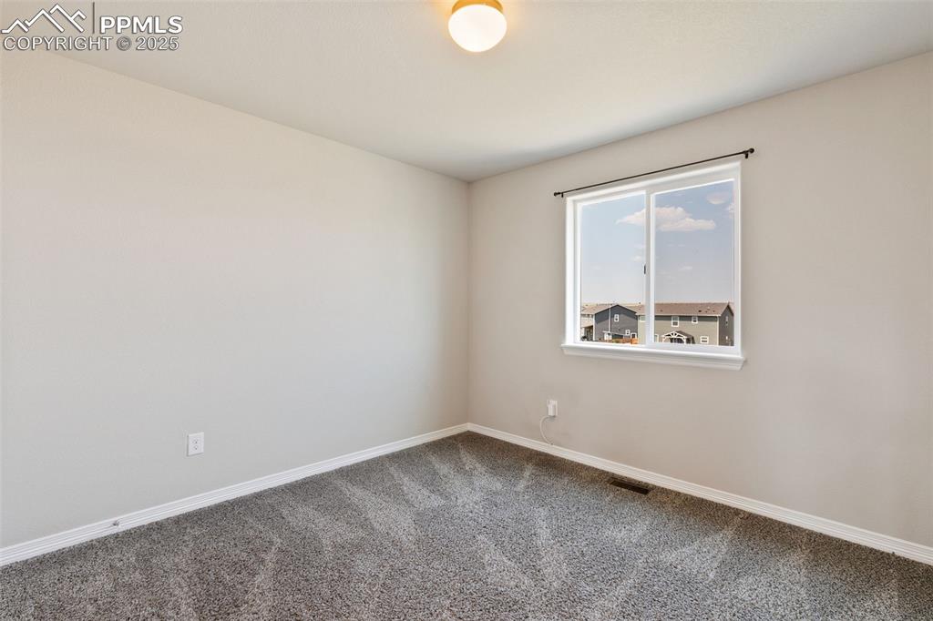 Image 19 of 28: Spare room featuring baseboards and carpet flooring