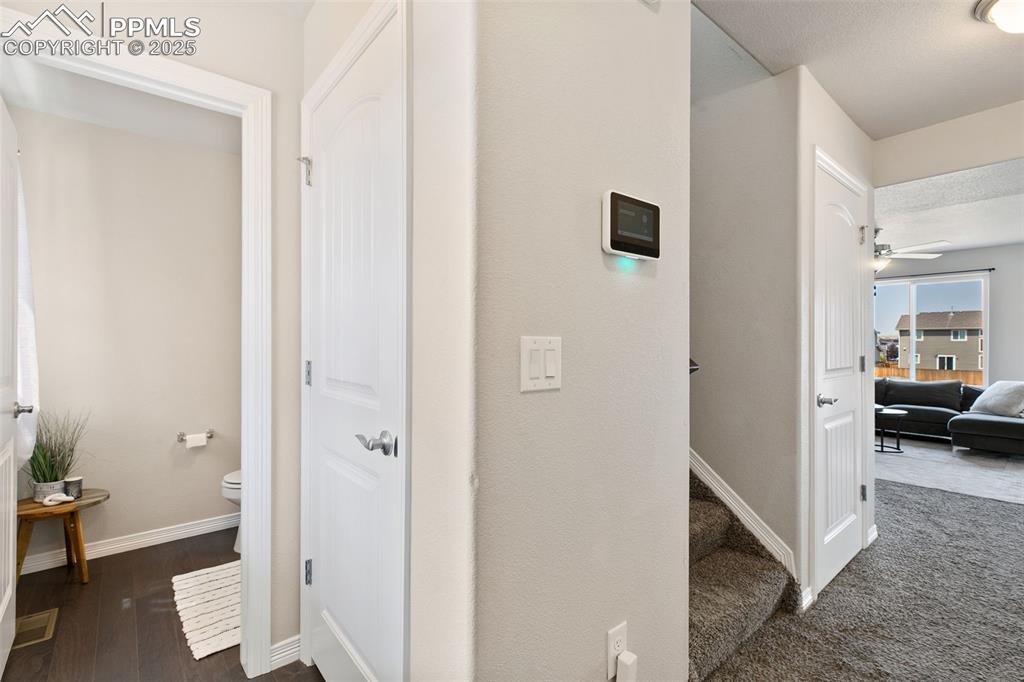 Image 2 of 28: Corridor with baseboards and dark wood-type flooring