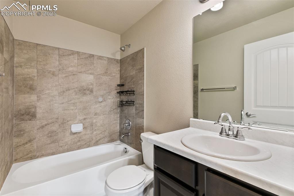 Image 23 of 28: Full bath with shower / bath combination, a textured wall, and vanity