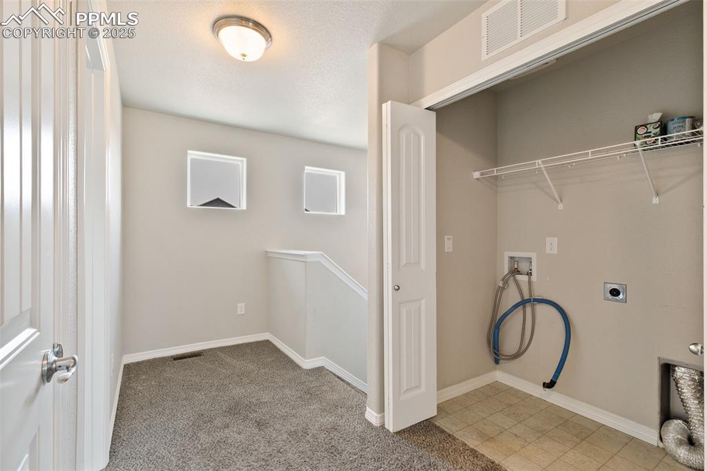 Image 25 of 28: Laundry area with hookup for a washing machine, electric dryer hookup, ligh