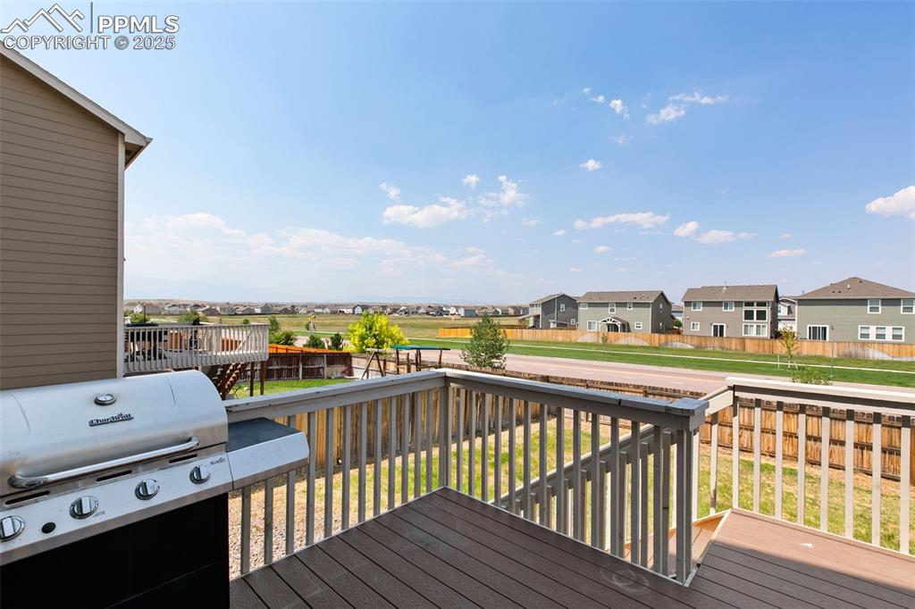 Image 26 of 28: Wooden deck featuring a residential view, a fenced backyard, and grilling a