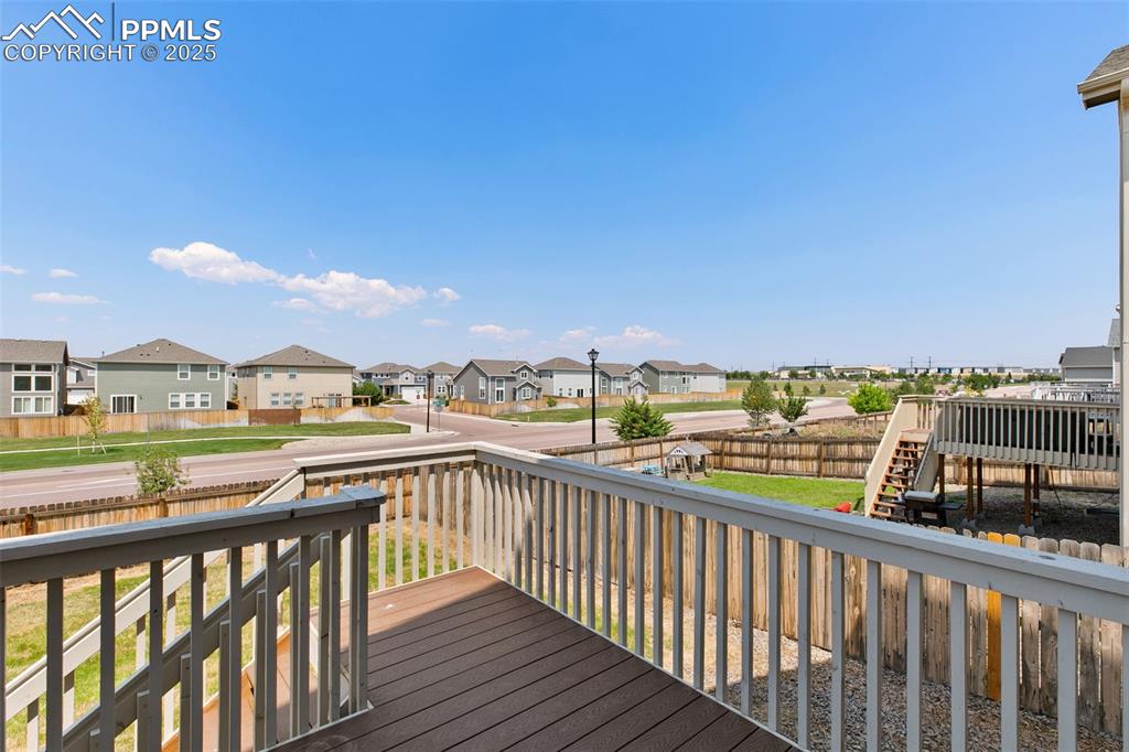 Image 27 of 28: Wooden deck featuring a fenced backyard, a residential view, and stairs